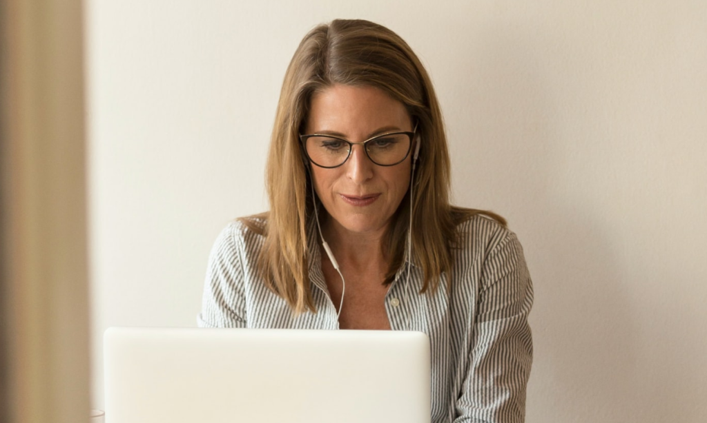 Woman using a laptop computer wearing headphones