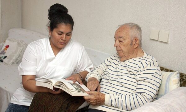 A man reading a book with his carer